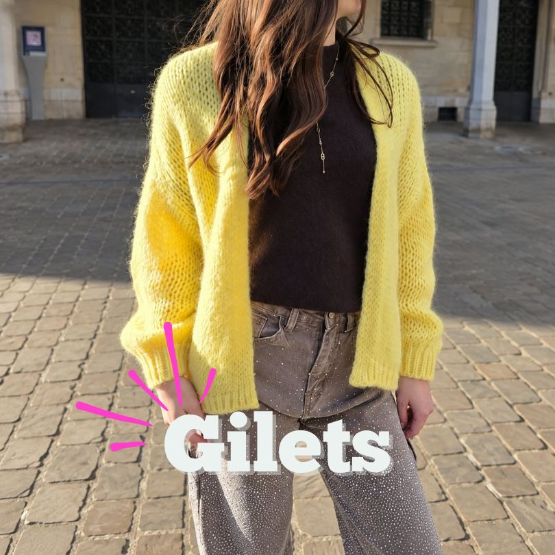 Gilet maille jaune pour femme porté sur un haut sombre et jean strassé.